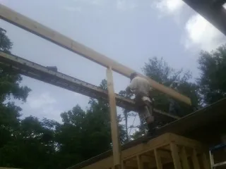 Carpenter setting a ridge beam over a new addition frame — Ice Dam Removal by Roofing Brothers in Windom