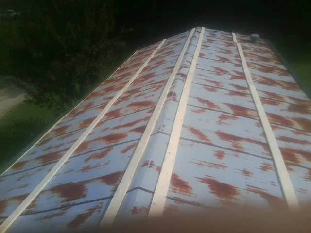Rusted metal roof panels with new wood purlins before replacement — Storm Damage Roof Repair in Windom by Roofing Brothers