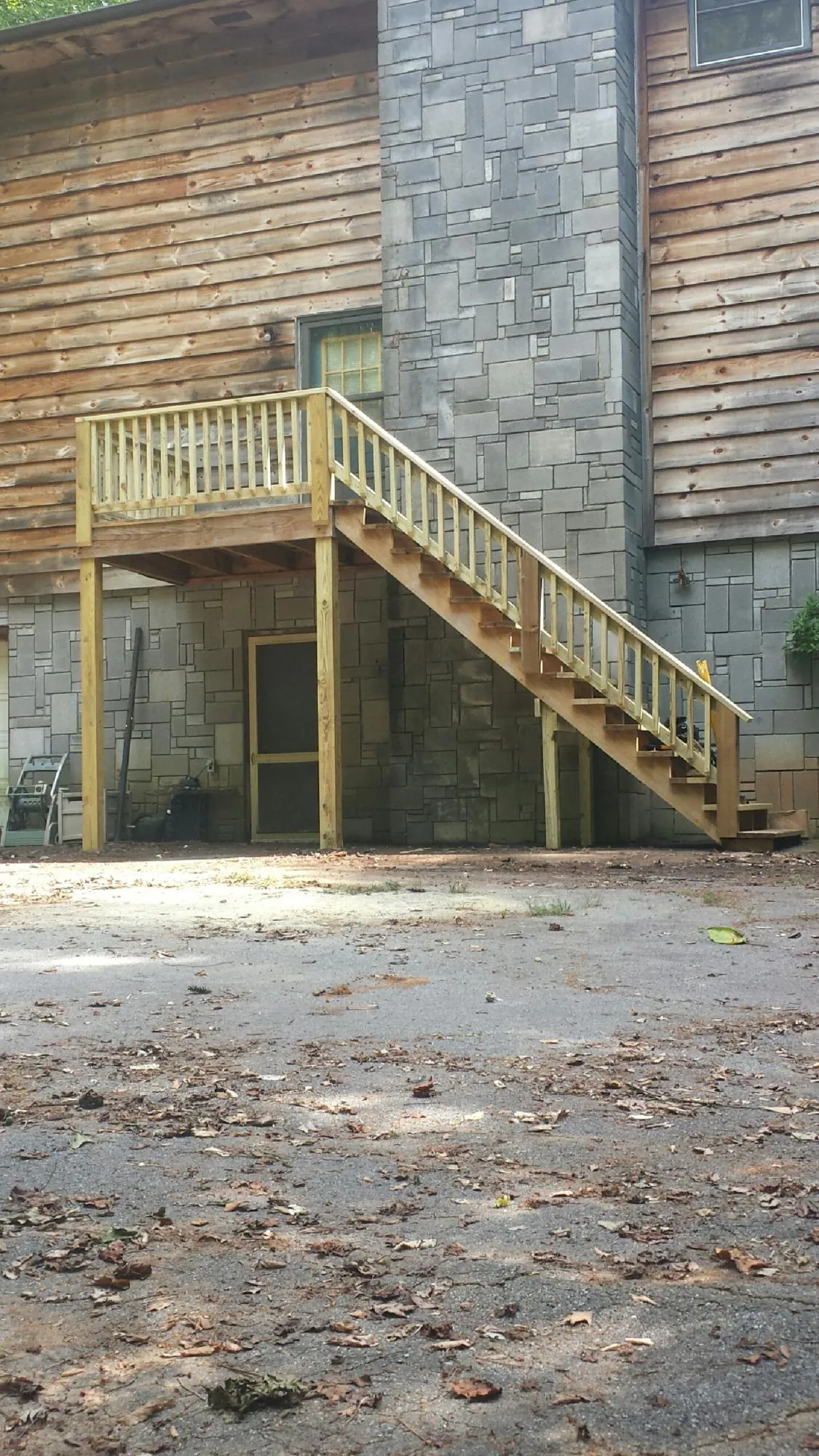 New pressure treated deck and stair landing on a log home in Windom