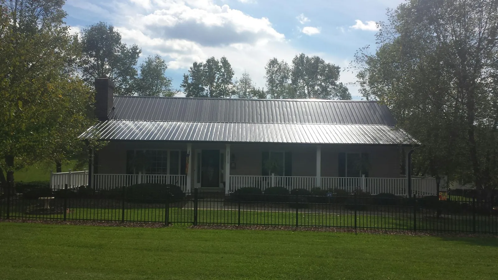 Gray metal roof on a brick ranch with a full width front porch — Gutter Guard Installation work by our crew in Windom
